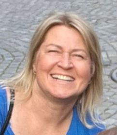 Bilde av en smilende dame med halvlangt blondt hår.