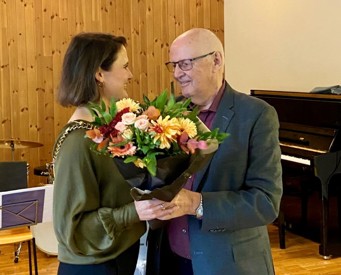 Bildet viser tidligere ordfører Kari Nessa Nordtun som gir en blomsterbukett til Rolf M. Amundsen på Eldredagen tidligere i 2023.